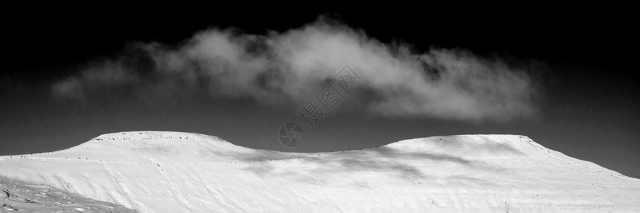 令人惊叹的冬季全景景观,雪覆盖着黑白相间的山图片