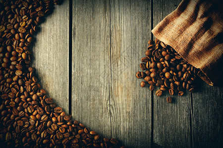 咖啡豆袋子木制背景上图片