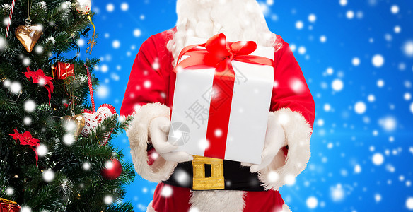 诞节,假日人的诞老人与礼品盒树蓝色的雪背景图片