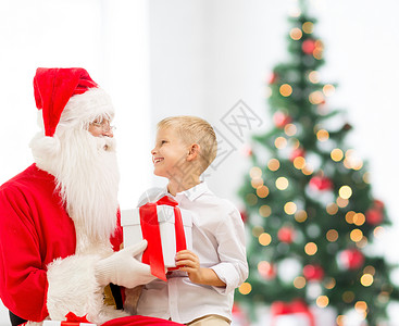 假期,童人的微笑的小男孩与诞老人礼物诞树灯光背景图片