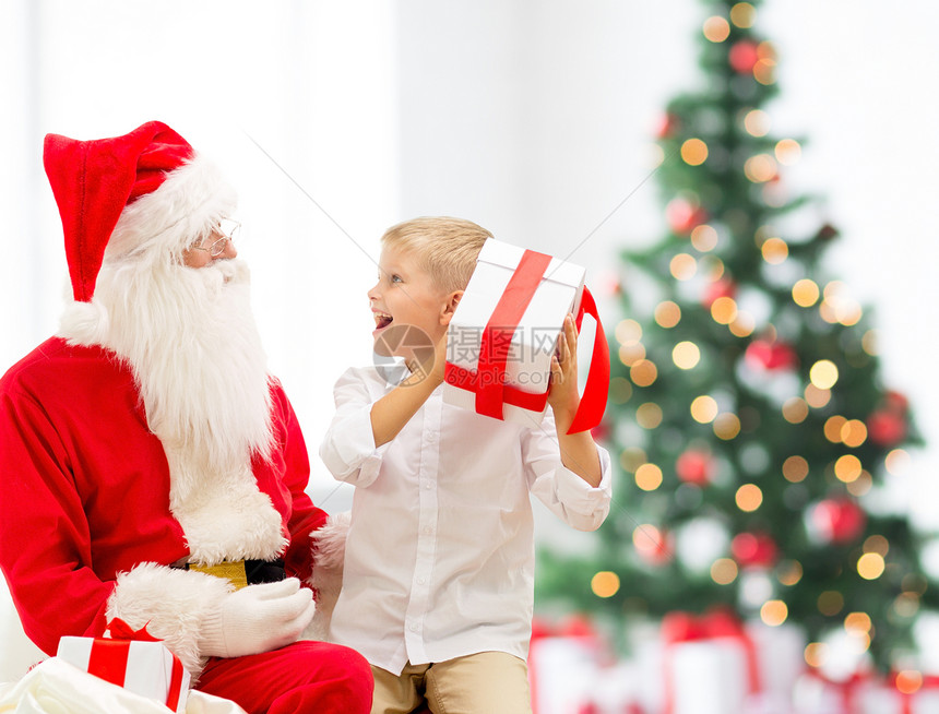 假期,童人的微笑的小男孩与诞老人礼物诞树灯光背景图片