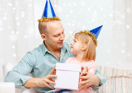 家庭,孩子,庆祝,节日快乐的人的快乐的父亲女儿戴着礼品盒的派帽图片