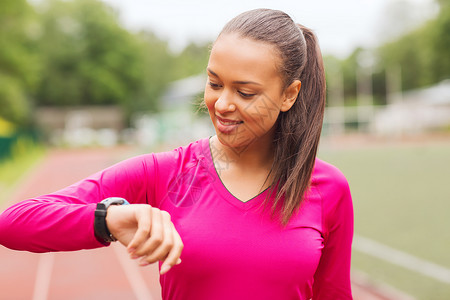 健身,运动,培训,技术生活方式的微笑的非裔美国妇女与心率手表轨道户外图片