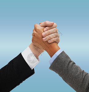 商业,人,国际竞争的双手,多种族摔跤握手蓝色背景图片