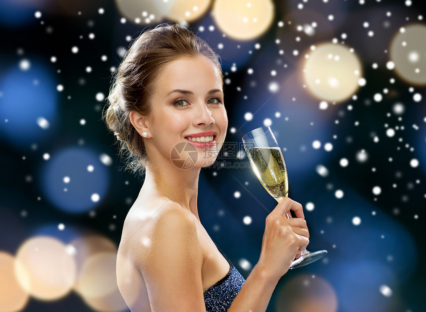 派,饮料,假日,诞节人们的微笑的女人穿着晚礼服,夜灯雪背景上喝着杯泡葡萄酒图片
