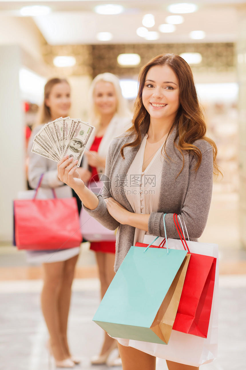 销售,消费主义人的快乐的轻妇女与购物袋美元现金商场图片