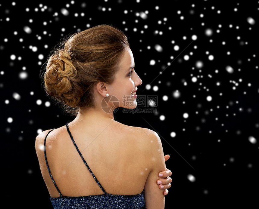 人,假日魅力微笑的女人晚礼服黑色雪背景后图片