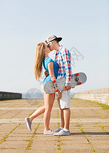假期,假期爱的夫妇与滑板亲吻户外图片