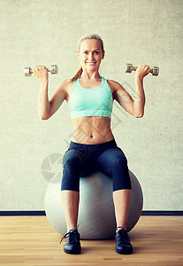 健身,运动,训练生活方式的微笑的女人与哑铃运动球健身房图片