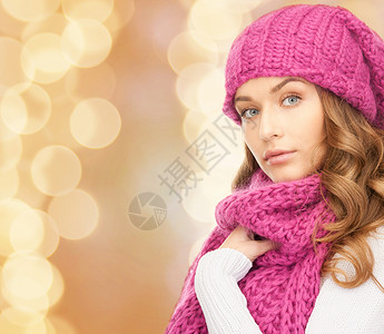 幸福,寒假,诞节人们的轻的女人戴着粉红色的帽子围巾,背景米色的灯光图片