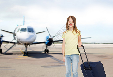 旅游,假期,童交通微笑的小女孩与旅行袋机场背景图片