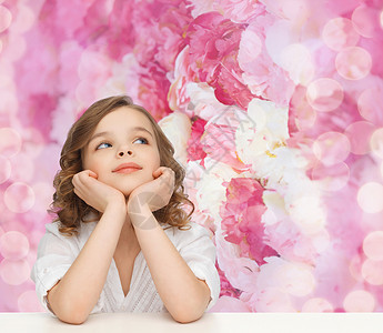 孩子,童,假期快乐的人的美丽的女孩坐桌子上,仰望着粉红色的花朵背景,梦想着图片