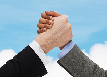 商业,人与竞争的近距离的两个人手手臂摔跤蓝天白云背景图片
