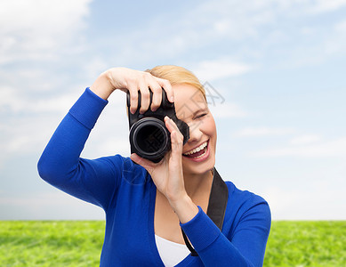 摄影,技术,夏天人的微笑的轻女人用数码相机蓝天草地背景上拍照图片