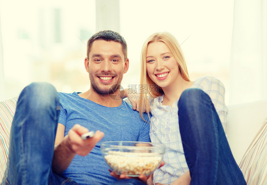 食物,爱,家庭幸福的微笑的夫妇爆米花家里看电影图片