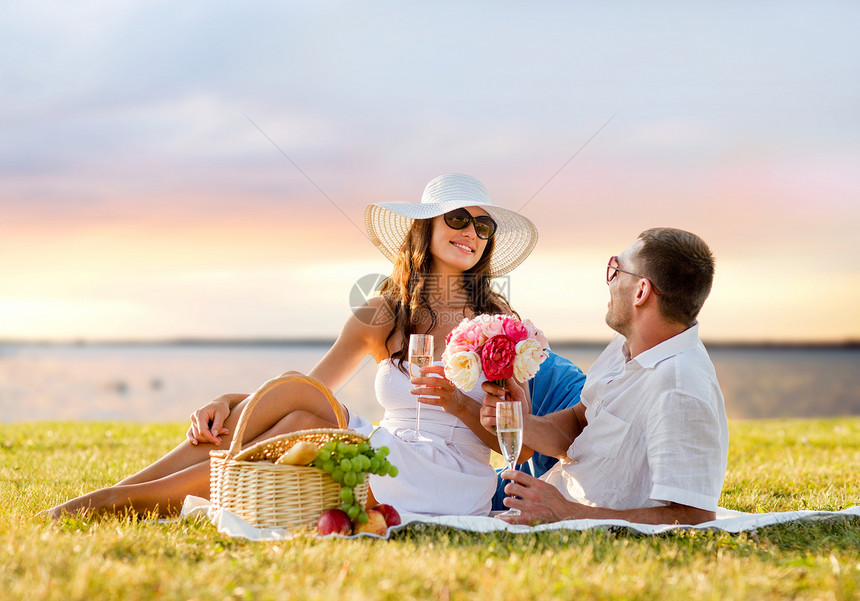 爱情,约会,人假期的微笑的夫妇晚上的海边背景下野餐时喝香槟图片