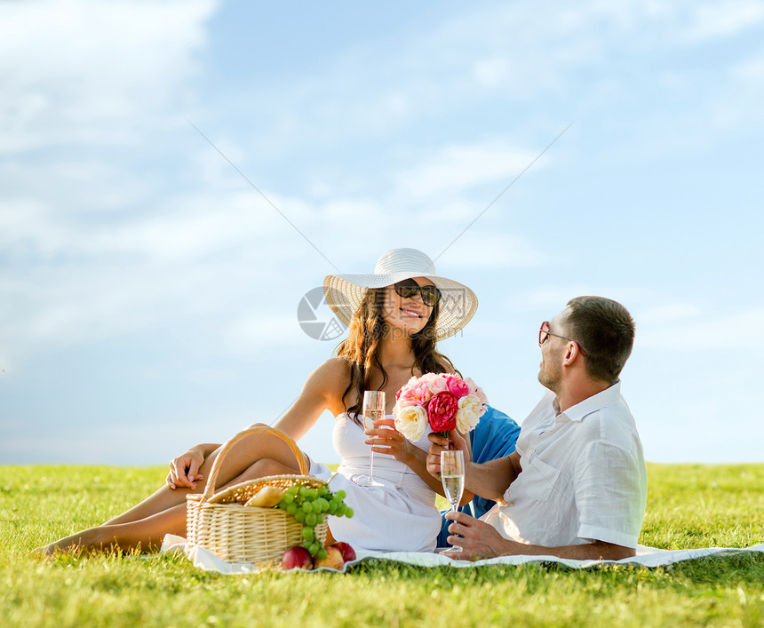 爱情,约会,人假期的微笑的夫妇户外野餐时喝香槟图片