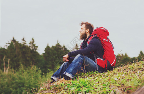 冒险,旅行,旅游,徒步旅行人的男人留着胡子红色背包坐地上图片