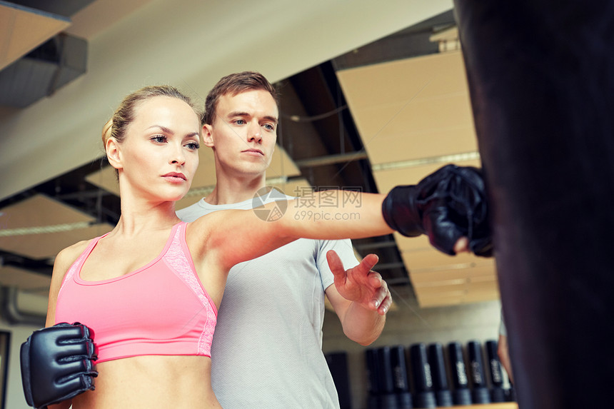 运动,健身,生活方式人的妇女与私人教练拳击袋健身房图片