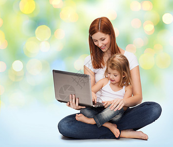 童,育儿技术快乐的母亲与可爱的小女孩笔记本电脑绿灯背景图片