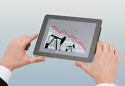 石油业务,能源危机,人技术近距离的人手平板电脑与泵千斤顶屏幕上的灰色背景图片