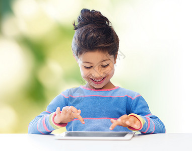 教育,儿童,技术人的快乐的小女孩与平板电脑绿色背景图片