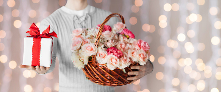 恭维节日,人,感情问候的特写的人着装满花的篮子礼品盒灯光背景上背景