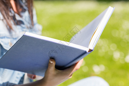 生活方式,暑假,教育,文学人的轻女孩阅读书籍坐公园的草地上图片