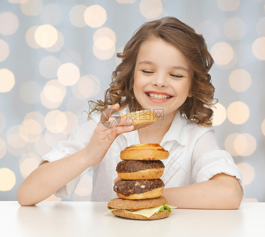 垃圾食品,健康的饮食,孩子人的,快乐的微笑女孩吃包子,甜甜圈汉堡节日灯光背景图片