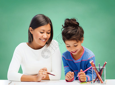 教育,学校,孩子,创造力快乐的人的快乐的老师女孩画绿色粉笔板背景图片