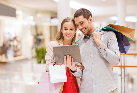 销售,消费主义,技术人的快乐的轻夫妇与购物袋平板电脑电脑商场图片