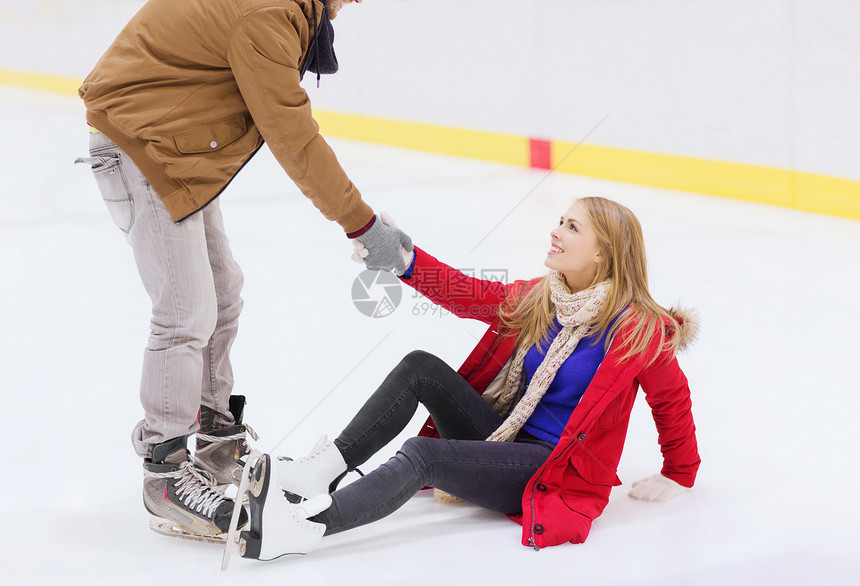 人,友谊,运动休闲的微笑的男人帮助女人溜冰场上升图片