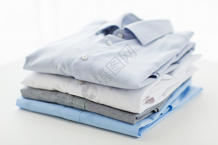 蓝色的布熨烫,洗衣,衣服,内务物品的熨烫折叠衬衫家里的桌子上背景