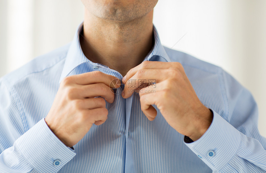 人,商业,时尚服装的密切男人打扮紧固按钮家里的衬衫图片