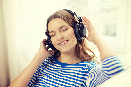 技术,音乐幸福微笑的轻女孩戴着耳机家图片