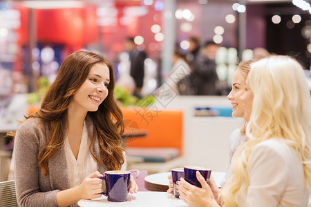 咖啡馆交谈饮料,沟通,友谊人的快乐的轻女人坐桌子上,商场咖啡馆里交谈背景