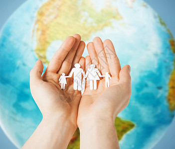 地球家庭素材人,人口,慈善生活近距离的人的手握纸家庭地球上蓝色的背景背景
