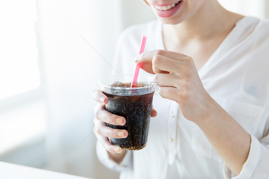 饮料,人生活方式的接近快乐的女人喝可口可乐塑料杯与稻草家图片