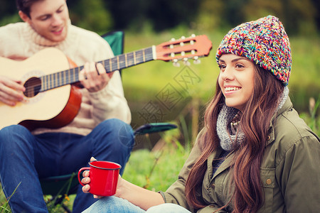 冒险,旅行,旅游人的微笑夫妇与吉他露营图片
