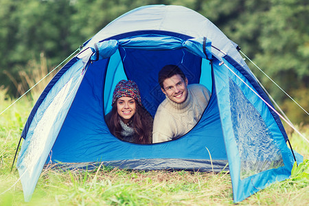 野营,旅游,徒步旅行人们的微笑的游客帐篷里往外看图片