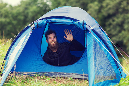野营,旅游,徒步旅行人们的微笑的男游客,胡须挥舞着帐篷图片