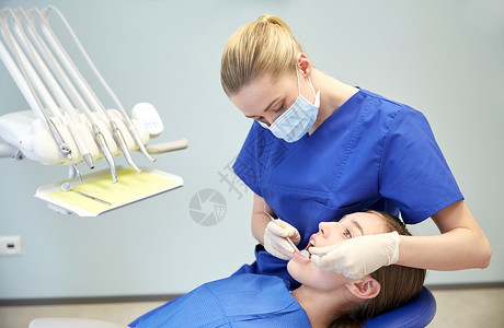 人,医学,口腔科保健快乐的女牙医用镜子探针检查病人女孩的牙齿牙科诊所办公室背景图片