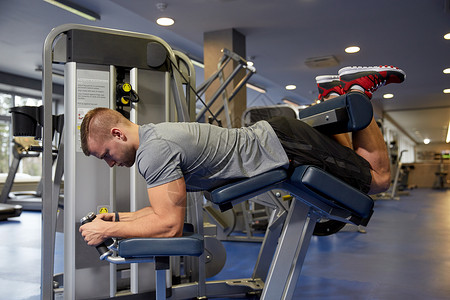 运动,健身,健美,生活方式人的男人锻炼弯曲肌肉腿部卷曲机健身房图片