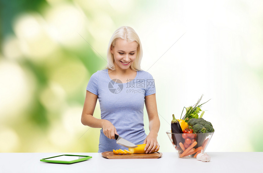 健康饮食,素食,饮食人们的微笑的轻妇女烹饪蔬菜与平板电脑电脑绿色的自然背景图片