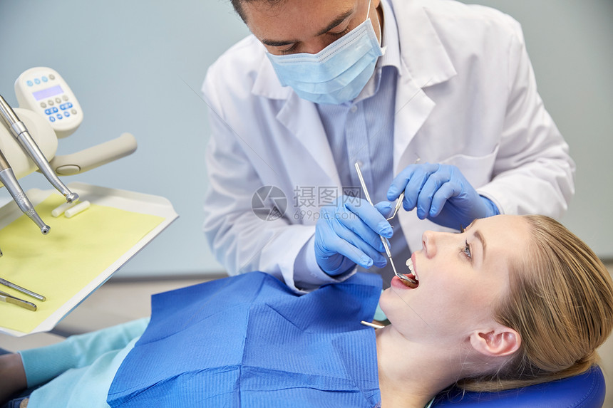人,医学,口腔医学保健男牙医具上戴着牙科镜,并牙科诊所办公室检查女病人的牙齿图片