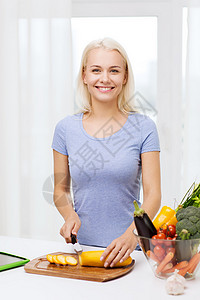 健康饮食,素食,烹饪,饮食人的微笑的轻女人家里切蔬菜图片