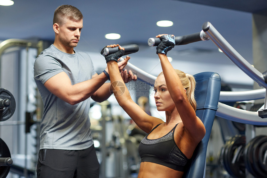 运动,健身,队合作人的轻的妇女私人教练健身机上伸展肌肉图片