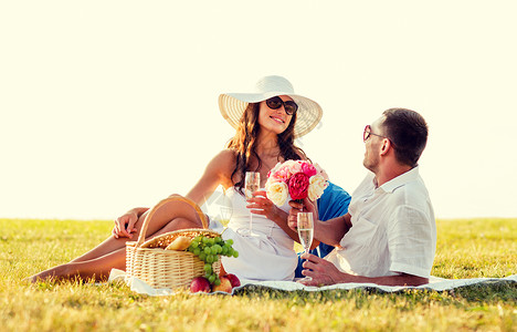 爱情,约会,人假期的微笑的夫妇野餐时喝香槟图片