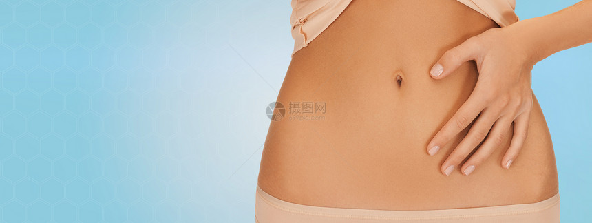 健康,消化,美丽,人减肥的近距离的女人指着腹部的蓝色背景图片