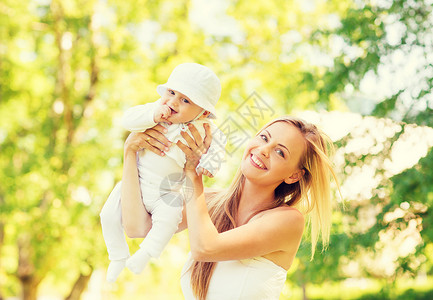 家庭,孩子父母的快乐的母亲抱着抚养小婴儿公园图片
